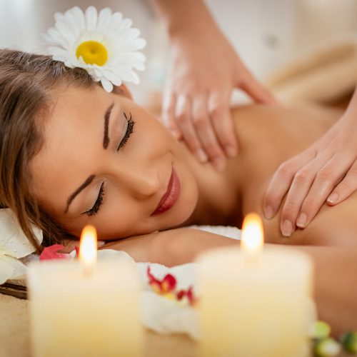 Beautiful woman enjoying during a shoulder massage at a spa.