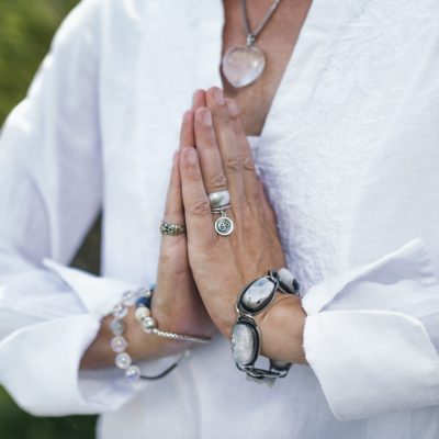 Close up image of female hands in prayer position outdoor. Self-care practice for wellbeing